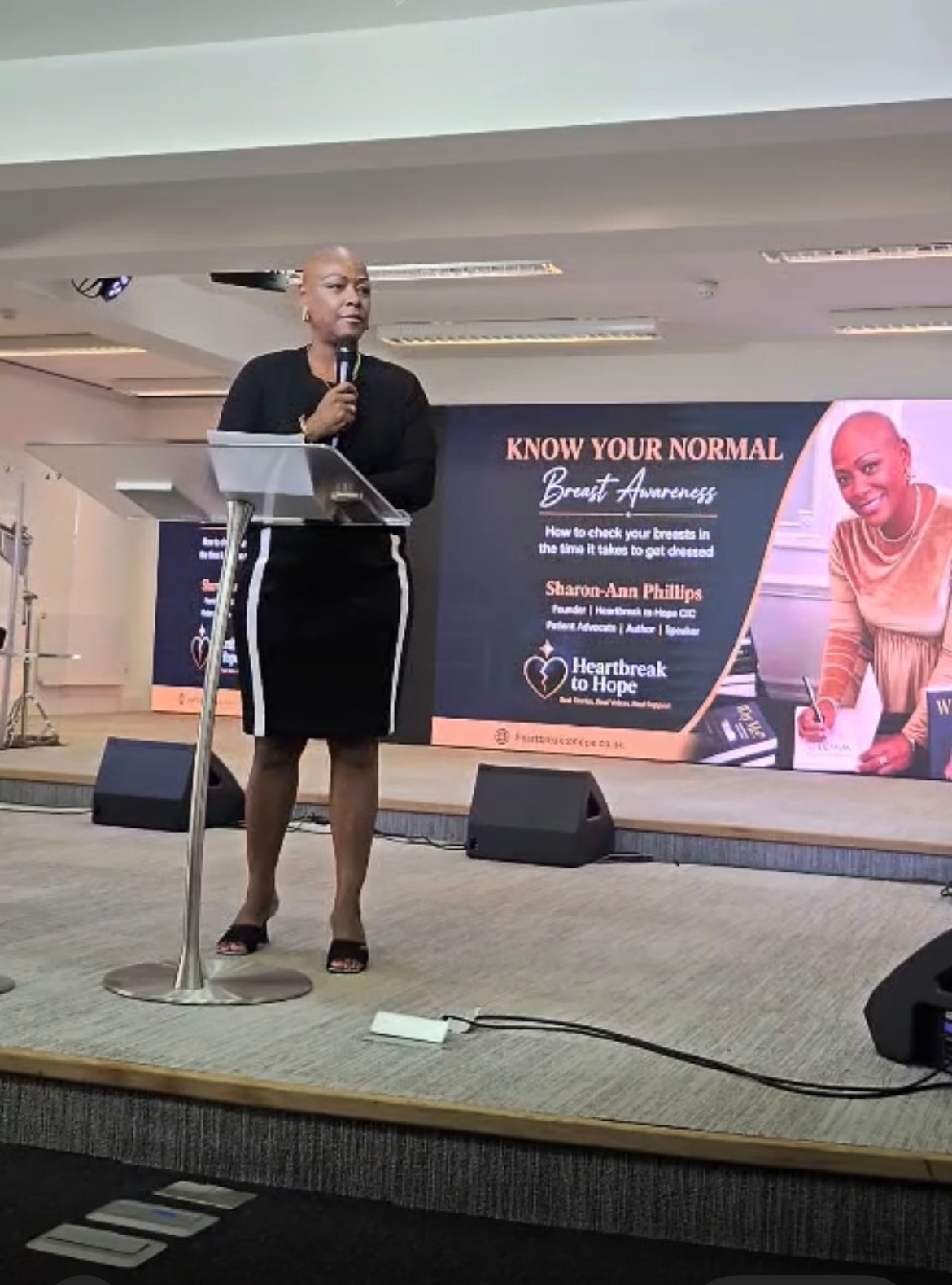 Sharon-Ann Phillips presenting Know Your Normal breast awareness session on stage