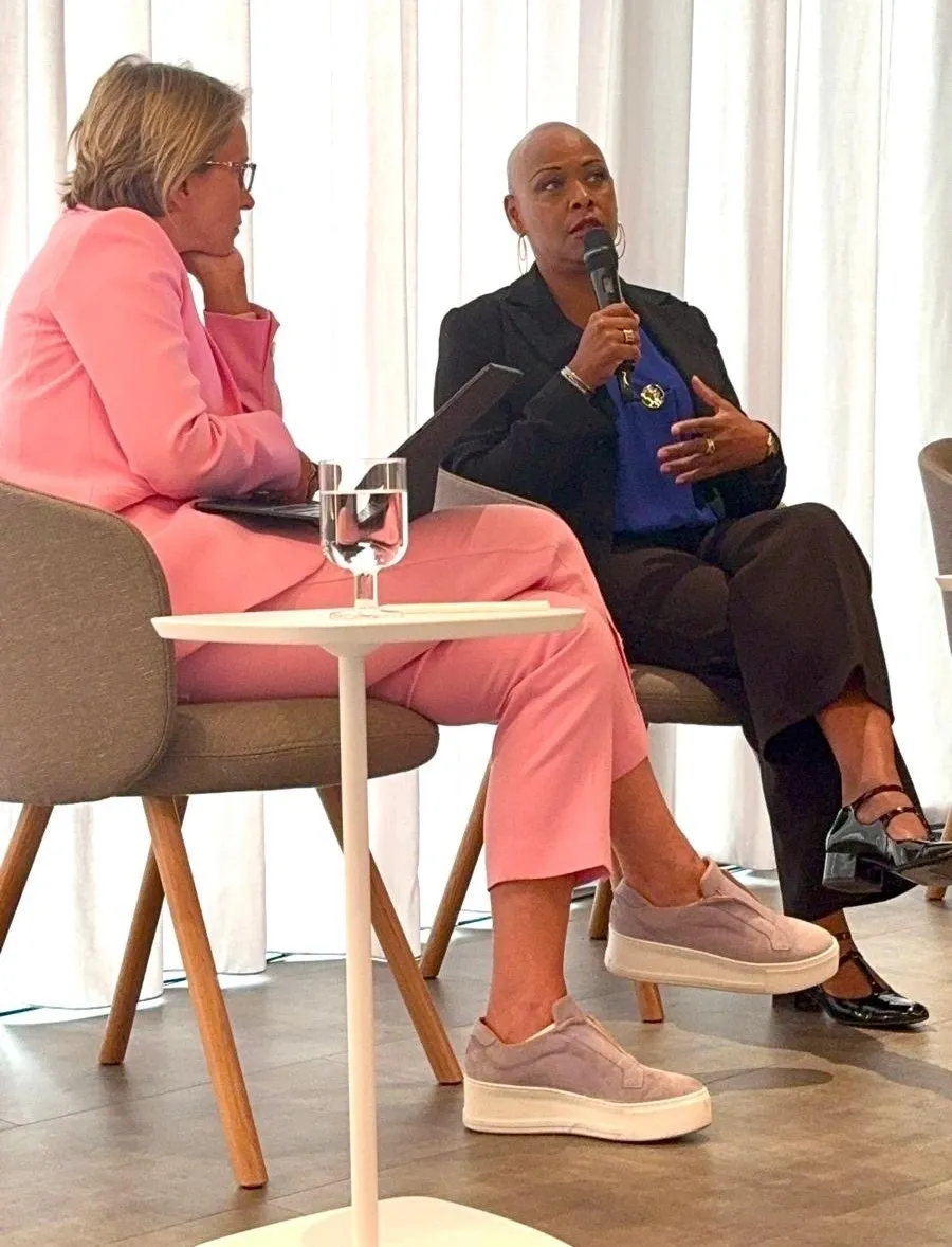 Two women engaged in a serious conversation during a formal event. Sharon-Ann Phillips and Emma Walmsley CEO GSK interview with Myeloma UK
